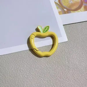 Yellow apple shaped spring ring keychain detail, cute lacquer bag charm DIY accessory.
