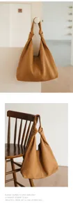 Minimalist soft leather shoulder bag with chic knotted handle, stylish commute hobo bag.