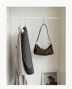 Detail shot of retro brown cowhide hobo shoulder bag, premium leather pillow underarm bag style.