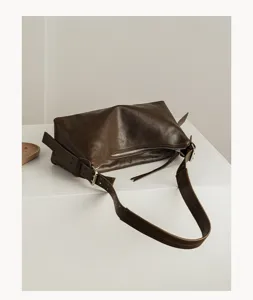 Detailed view of genuine leather hobo pillow bag showing smooth texture and metal hardware.