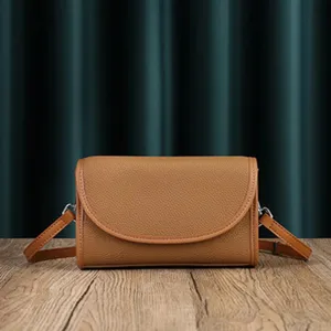 Brown leather shoulder bag detail showing premium texture and classic flap crossbody design.