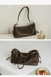 Detail view of dark brown leather hobo shoulder bag showing soft texture, zippers and metal buckles.