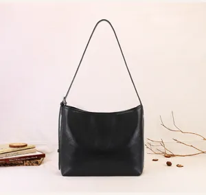 Detail view of the black slouchy soft leather shoulder bag with simple minimalist design.
