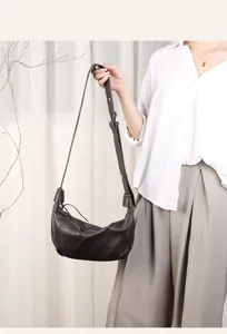 Detailed view of the dark brown leather dumpling shoulder bag, showing soft texture and strap.