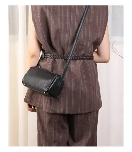 Stylish black leather cylindrical crossbody bag for women, premium minimalist barrel design.