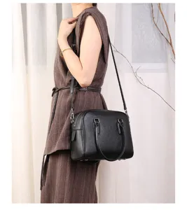 Black leather Boston shoulder bag for women, stylish bowling crossbody bag for daily commute.