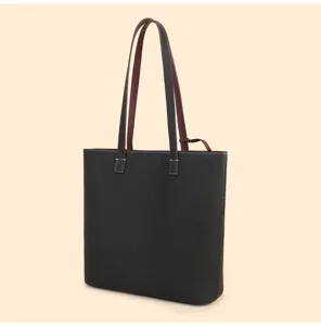 Detailed view of black genuine leather tote bag with contrasting burgundy dual shoulder straps.