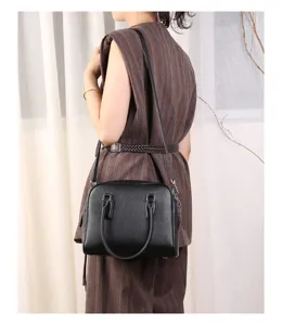 Detailed shot of a stylish black leather Boston shoulder bag, perfect for daily commuting.