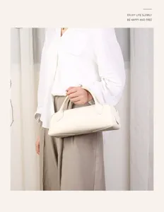 Genuine leather minimalist Boston bag for women, commuter pillow handbag in elegant cream color.