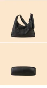 Black leather hobo shoulder bag detail, soft pebbled texture and front zipper pocket.