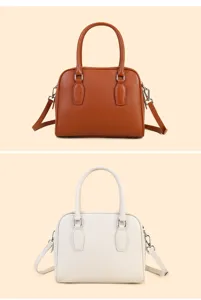 Classic pebbled leather Boston bag detail, dual top handles, stylish metal hardware accents.