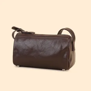 Dark brown leather cylindrical shoulder bag, chic retro barrel crossbody bag for women.