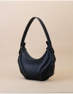 Close-up of premium black leather underarm bag featuring contrast white stitching and details.