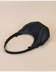 Black leather crescent underarm bag with contrast stitching, stylish commuter shoulder purse.