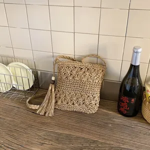 Detalle de bolso cruzado tejido, bolso de paja informal con borla, diseño elegante.