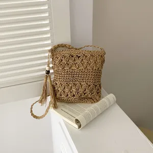 Bolso cubo cruzado de paja tejida con borla y abalorios de madera, estilo minimalista.