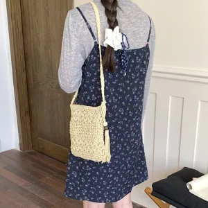 Vista detallada del bolso cruzado de paja tejida informal con un elegante diseño de borlas.