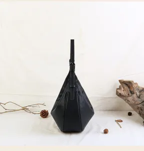 Detailed view of black genuine leather crescent hobo shoulder bag with adjustable strap and chic design.