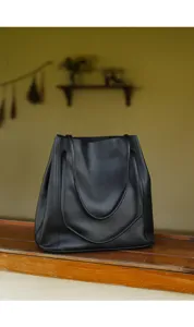 Detailed view of the black leather tote bag showing soft texture and fine stitching work.