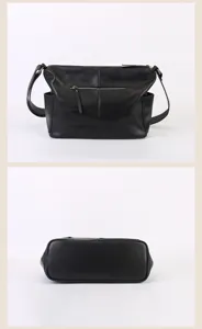 Close-up detail view of black leather crossbody bag featuring front zipper and side pockets.
