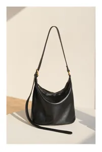 Detail view of the black soft leather hobo shoulder bag showing fine texture and metallic hardware.