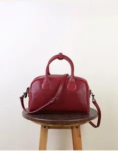 Red leather vintage Boston bag detail, stylish retro women handbag and crossbody bag.