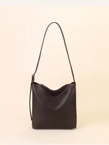 Simple dark brown genuine leather shoulder bag detail, soft bucket design with adjustable strap.