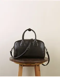 Detail view of retro dark brown leather Boston bag, classic everyday handbag style