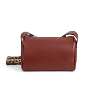Brown leather cylindrical crossbody bag with ethnic strap, stylish shoulder bag for women.
