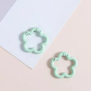 Nahaufnahme von hellgrünen Blumen-Federringen, Metall-DIY-Zubehör für Taschen und Schlüsselanhänger.