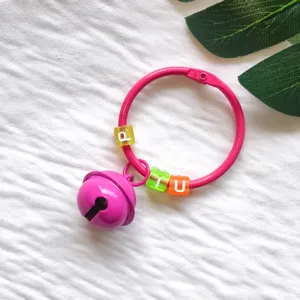 Rosa Metallring Schlüsselanhänger mit Glöckchen und bunten Buchstabenperlen als DIY Taschenschmuck.
