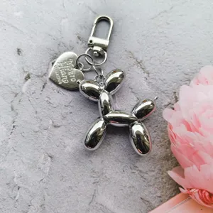 Silver balloon dog keychain detail view, stylish metal bag charm and pendant ornament.