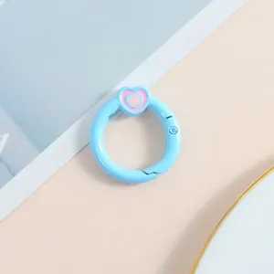 Primer plano detallado del anillo de resorte azul claro con corazon para llaveros DIY.