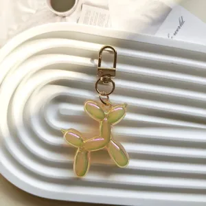 Close-up detail of the iridescent jelly balloon dog keychain pendant with gold metal hardware.