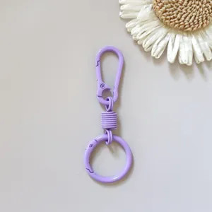 Detail view of purple zinc alloy spring keychain ring with flexible buckle and smooth finish.