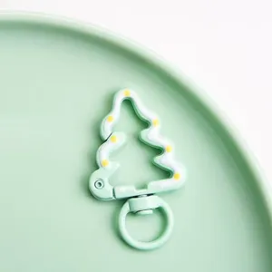 Close-up detail shot of Christmas tree alloy spring buckle keychain showing fine enamel craft.