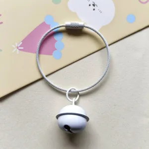Detailed view of white jingle bell with steel wire keyring, perfect for bags and keys.