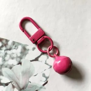 Moschettone girevole in metallo rosa portachiavi con campanello, accessorio per borsa.