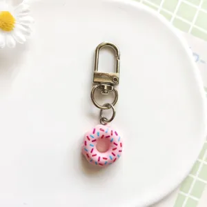 Schattige roze donut sleutelhanger detailopname, hars eten speelgoedhanger met metalen haak.