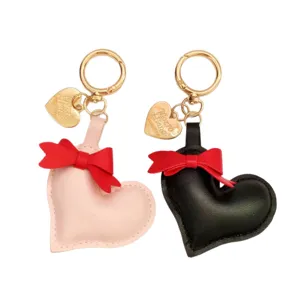 Cute heart leather keychain with red bow charm, stylish car key ring and bag accessory.