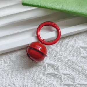 Metal candy colored bell pendant detail shot, red baking paint keychain DIY accessory.