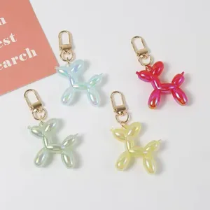 Close-up detail shot of colorful jelly balloon dog keychains with gold metal clasps for bags.
