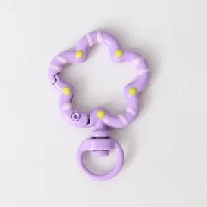 Purple flower shaped diy keychain clasp detail, enamel metal snap hook accessory close up.