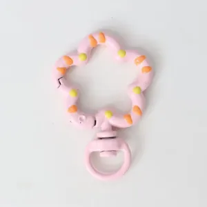 Detail shot of the pink flower-shaped spring snap hook keychain accessory with colorful paint.