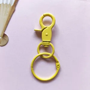Dettaglio portachiavi con moschettone in metallo giallo, accessorio fai da te color caramella.