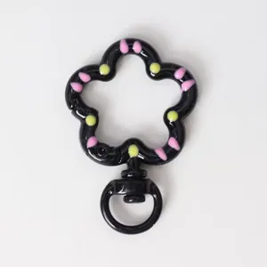 Closeup detail of the black flower shaped drip oil spring snap hook keychain diy accessory.
