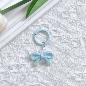 Close-up detail view of the light blue UV plated bow keychain charm with spring clasp.