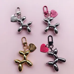Detail view of balloon dog keychain with heart pendant, metallic finish, stylish bag charm.