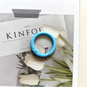 Blue metal spring ring keychain hardware detail, durable round clasp clip for bags and crafts.