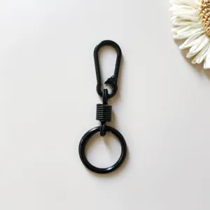Close-up view of the black zinc alloy spring keychain featuring smooth rebound mechanism details.